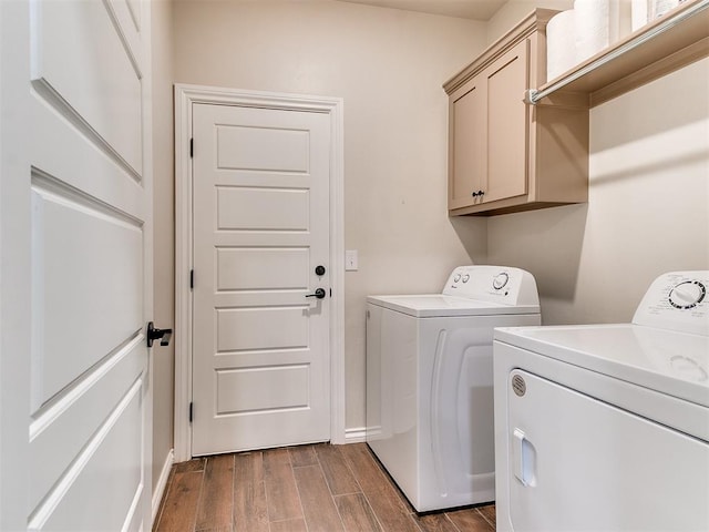 washroom with washing machine and dryer, dark hardwood / wood-style flooring, and cabinets