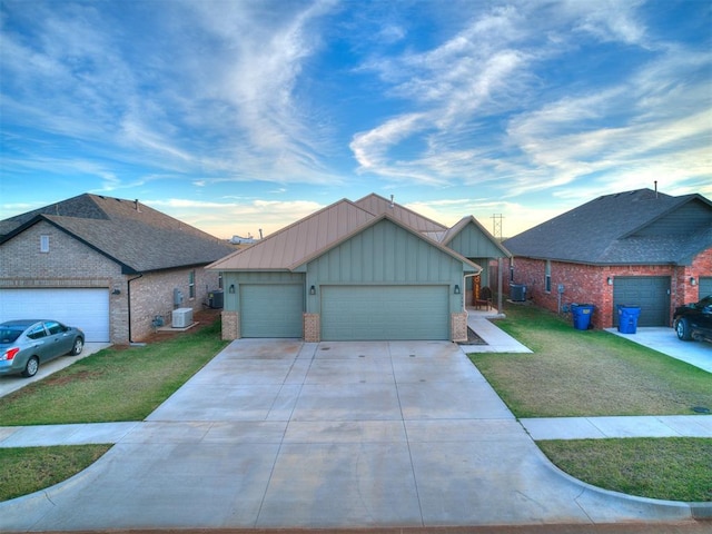 view of front of house with central AC, a front yard, and a garage