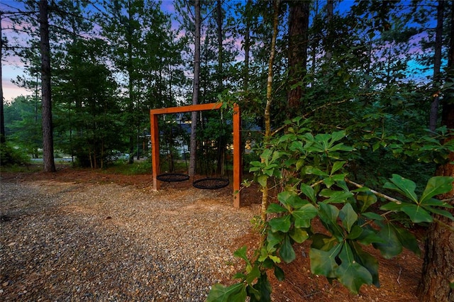 yard at dusk featuring a playground