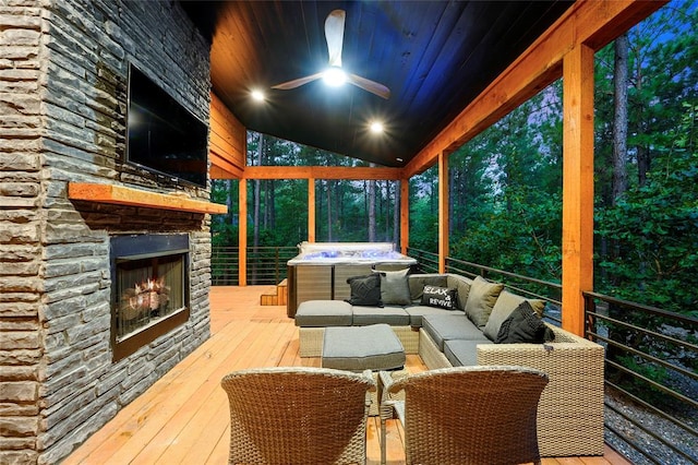 wooden deck with an outdoor living space with a fireplace and ceiling fan