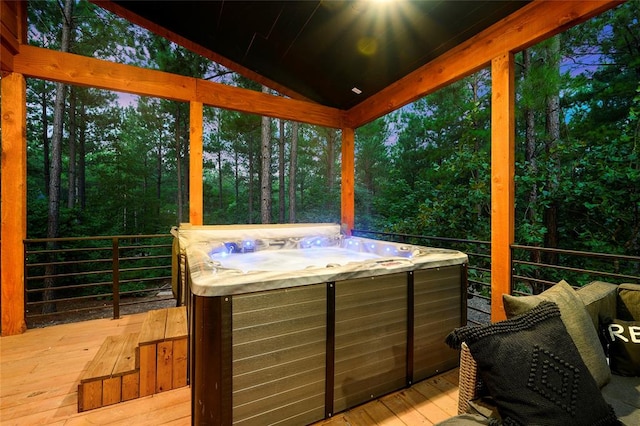 sunroom with a hot tub and lofted ceiling