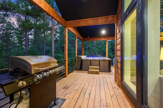 deck at dusk featuring area for grilling and a hot tub