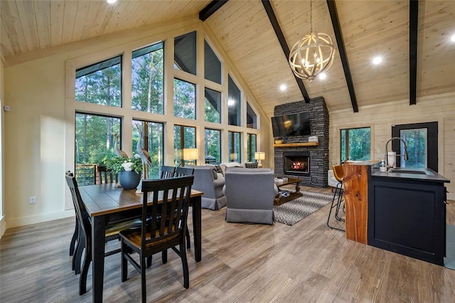119 Secluded Cir, Broken Bow, OK 74728 - dining area with a stone fireplace, a wooden ceiling with exposed beams, high vaulted ceiling, light wood-type flooring, and healthy amount of natural light