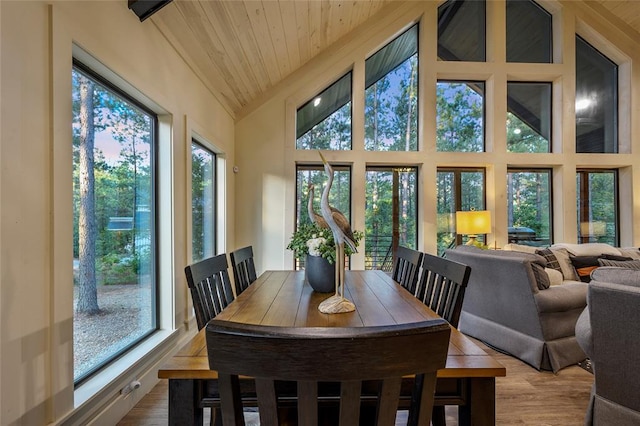 dining space featuring hardwood / wood-style flooring, high vaulted ceiling, and wood ceiling