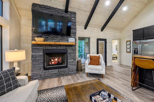 living room with high vaulted ceiling, a stone fireplace, light hardwood / wood-style flooring, beam ceiling, and wood ceiling