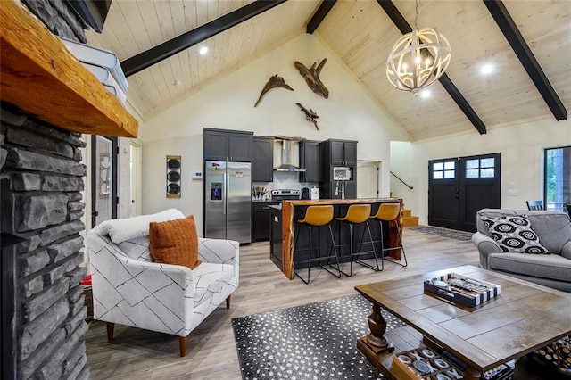 living room with light hardwood / wood-style flooring, high vaulted ceiling, beamed ceiling, and an inviting chandelier