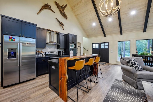 119 Secluded Cir, Broken Bow, OK 74728 - kitchen featuring appliances with stainless steel finishes, open floor plan, wall chimney exhaust hood, a chandelier, and high vaulted ceiling