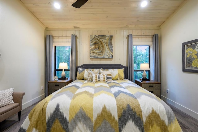 bedroom with ceiling fan, dark hardwood / wood-style floors, wooden ceiling, and wooden walls