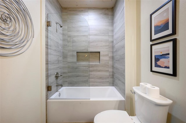 bathroom featuring tiled shower / bath combo and toilet