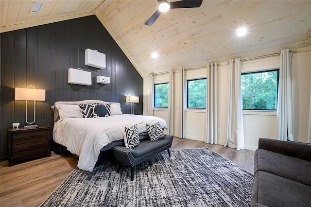 bedroom with multiple windows, ceiling fan, lofted ceiling, and hardwood / wood-style flooring