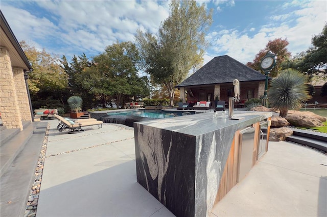 view of pool with a patio area and a bar