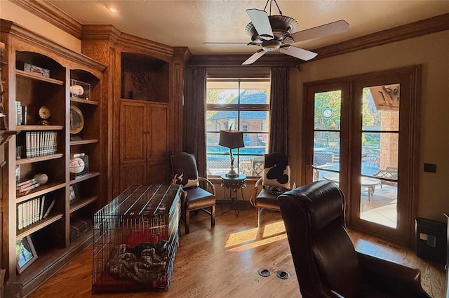 office with wood-type flooring, a wealth of natural light, crown molding, and ceiling fan