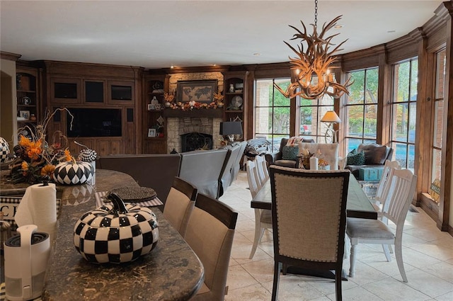 dining space featuring a fireplace, light tile patterned floors, and a chandelier