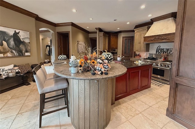 kitchen with sink, crown molding, an island with sink, appliances with stainless steel finishes, and custom exhaust hood