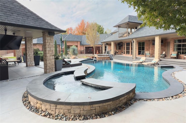 view of swimming pool with a patio area, an in ground hot tub, and pool water feature