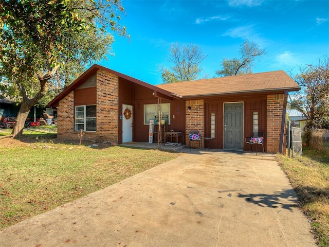 ranch-style home featuring covered porch and a front yard