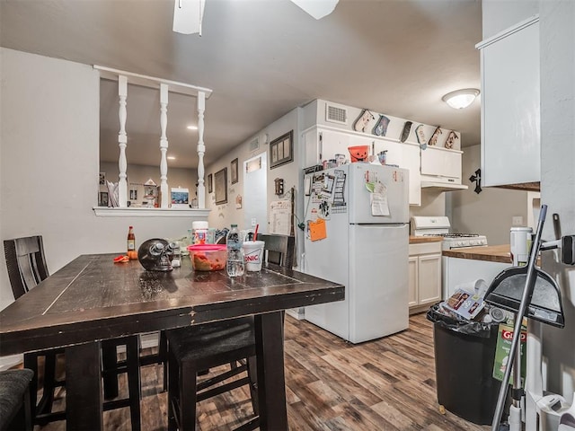 kitchen featuring white cabinets, wood-type flooring, white appliances, and wooden counters