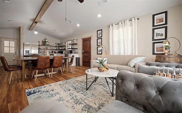 living room with vaulted ceiling with beams, ceiling fan, and hardwood / wood-style flooring