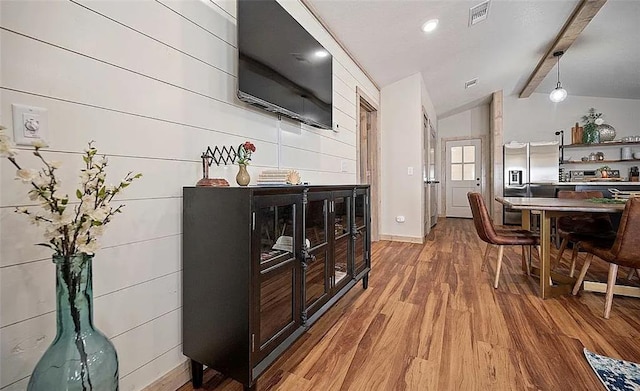 interior space featuring vaulted ceiling with beams and hardwood / wood-style flooring