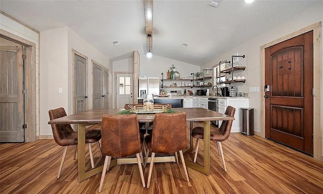 dining area featuring french doors, light wood-type flooring, lofted ceiling, and sink