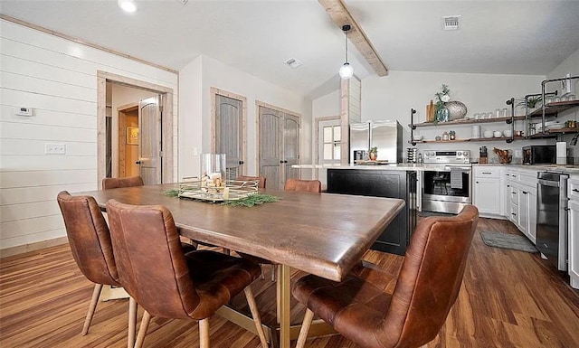 dining area featuring dark hardwood / wood-style flooring, lofted ceiling with beams, and wood walls