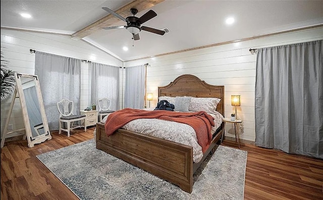 bedroom featuring ceiling fan, wooden walls, lofted ceiling with beams, and dark hardwood / wood-style floors