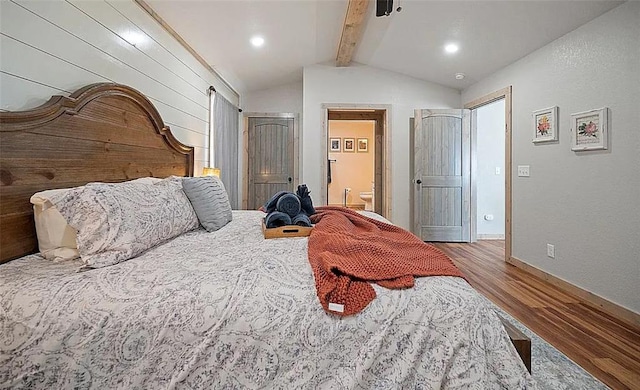 bedroom with lofted ceiling with beams, wood-type flooring, and ensuite bath