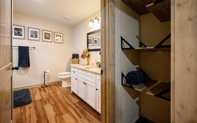 bathroom with hardwood / wood-style floors, vanity, and toilet