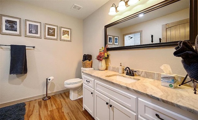 bathroom with vanity, wood-type flooring, and toilet