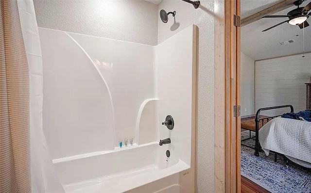 bathroom featuring shower / bath combination with curtain, a textured ceiling, and ceiling fan