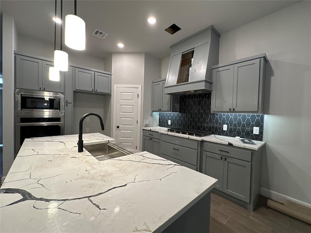 kitchen featuring custom exhaust hood, dark wood-type flooring, sink, hanging light fixtures, and stainless steel appliances