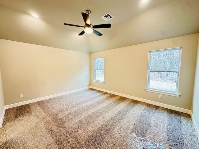 spare room featuring carpet flooring, lofted ceiling, ceiling fan, and a healthy amount of sunlight