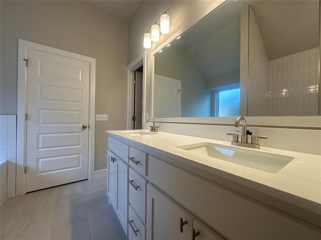 bathroom with tile patterned floors, vanity, and vaulted ceiling