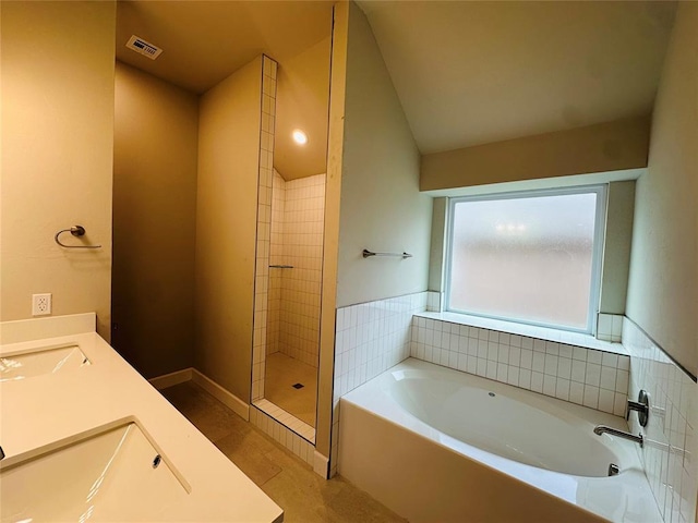 bathroom featuring tile patterned floors, vanity, shower with separate bathtub, and vaulted ceiling