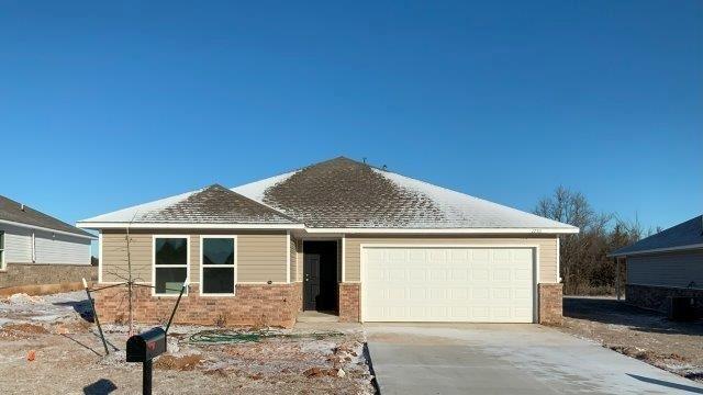 view of front of house with a garage and central air condition unit