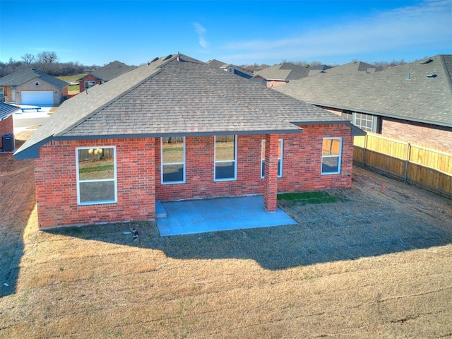 rear view of house featuring a lawn and a patio