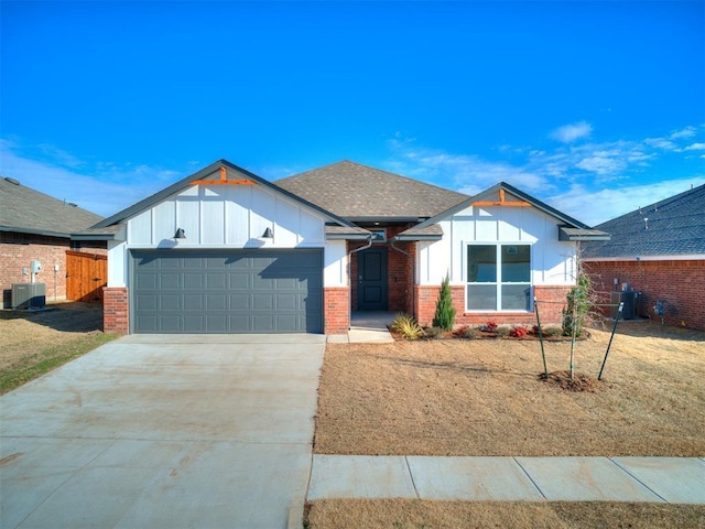 view of front facade with a front yard, a garage, and central air condition unit