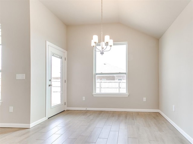 interior space with light hardwood / wood-style flooring, lofted ceiling, and a notable chandelier