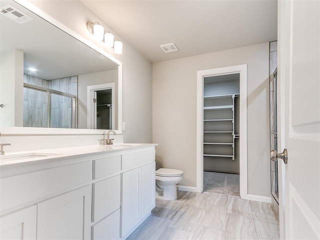 bathroom featuring vanity, toilet, and a shower with door