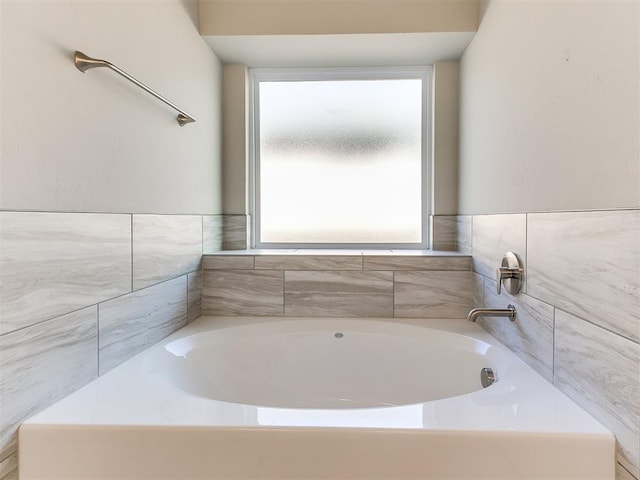 bathroom featuring a bath and plenty of natural light