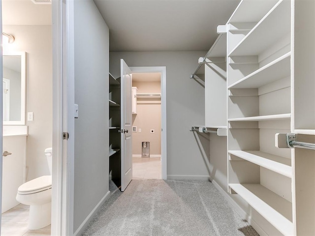 walk in closet featuring light carpet