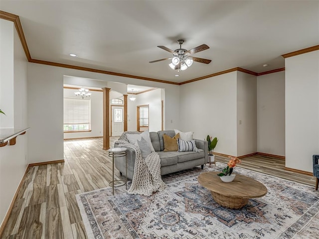 living room with ornate columns, ceiling fan, crown molding, and light hardwood / wood-style floors