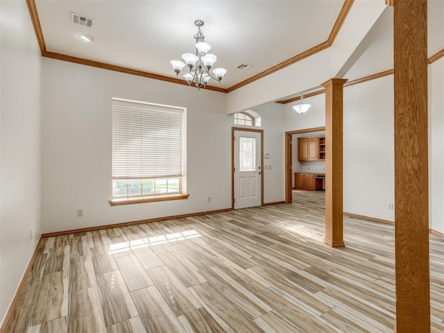 interior space featuring light hardwood / wood-style floors, an inviting chandelier, ornamental molding, and ornate columns