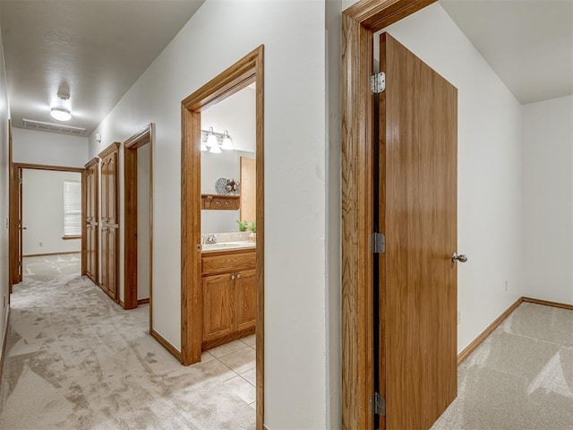 hall featuring light colored carpet and sink