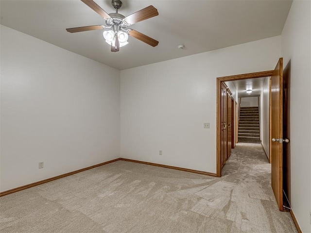 carpeted spare room featuring ceiling fan