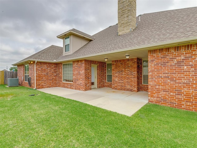 rear view of house featuring central air condition unit, a patio area, and a lawn