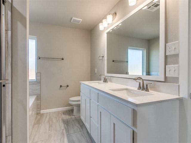 bathroom with vanity, toilet, and a bathtub