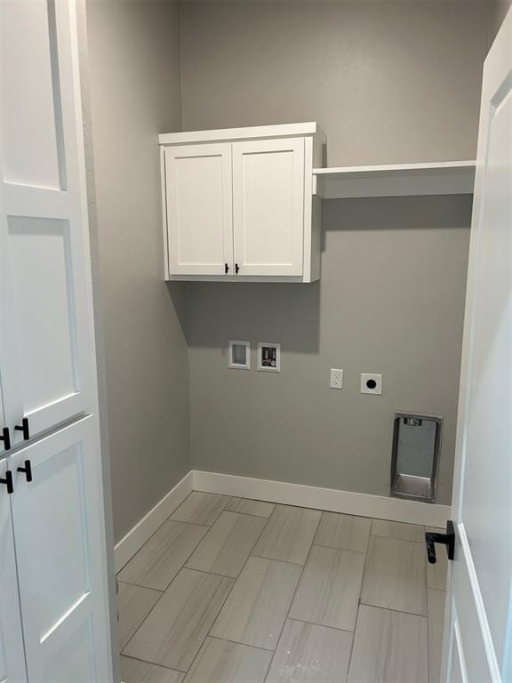 laundry room featuring electric dryer hookup, hookup for a washing machine, and cabinets