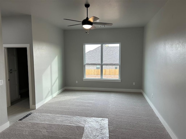 carpeted spare room featuring ceiling fan