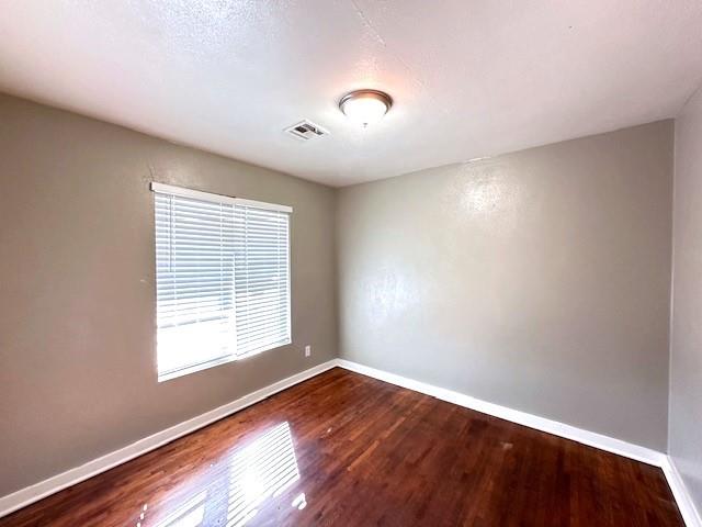 spare room featuring dark wood-type flooring